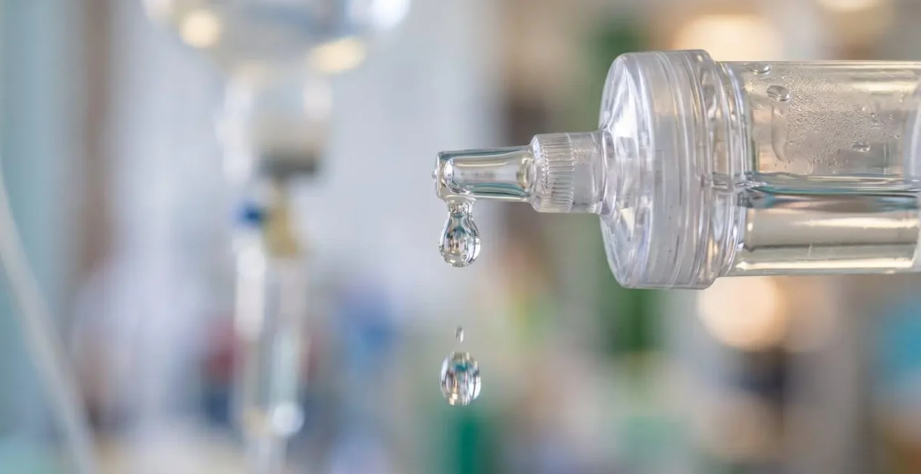 Close-up macro view of IV fluid administration setup for treating dehydrated puppies